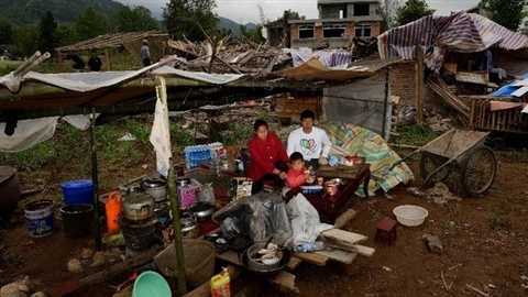 Family photos taken in front of dismantled houses in quake-hit Lushan